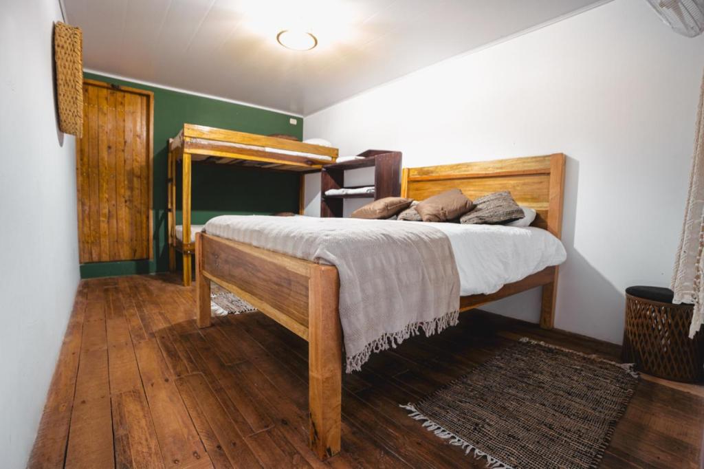 1 dormitorio con cama de madera en una habitación en Veragua Rainforest, en Puerto Limón
