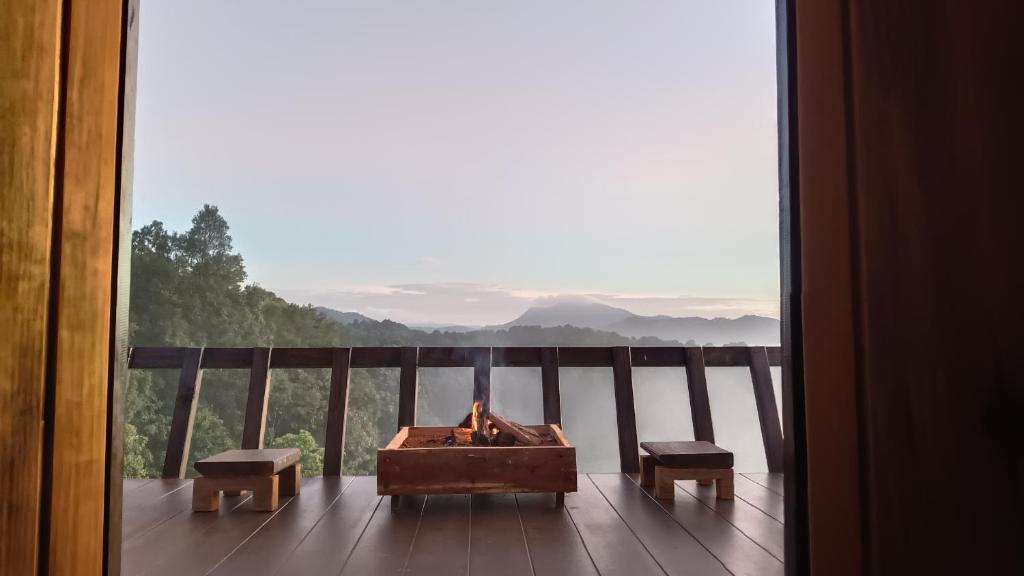 a fireplace on a balcony with a view of the water at ไร่นิธิสุนทร nithisoonthon farmstay in Mae Hong Son