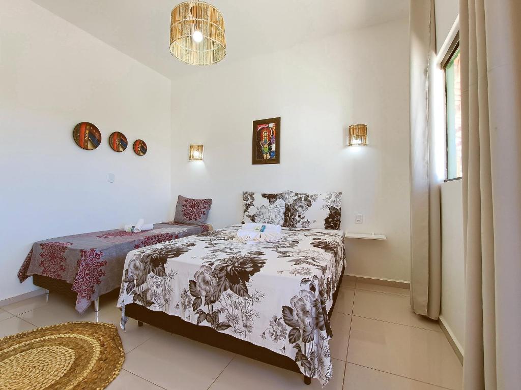 1 dormitorio con 2 camas y ventana en Villa Madu Milagres à 300 metros da praia, en São Miguel dos Milagres