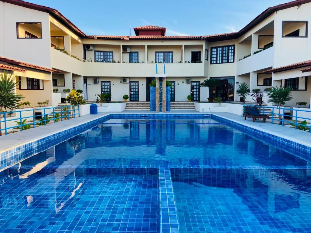 a swimming pool in front of a building at Hotel e Pousada Canoa Quebrada in Canoa Quebrada