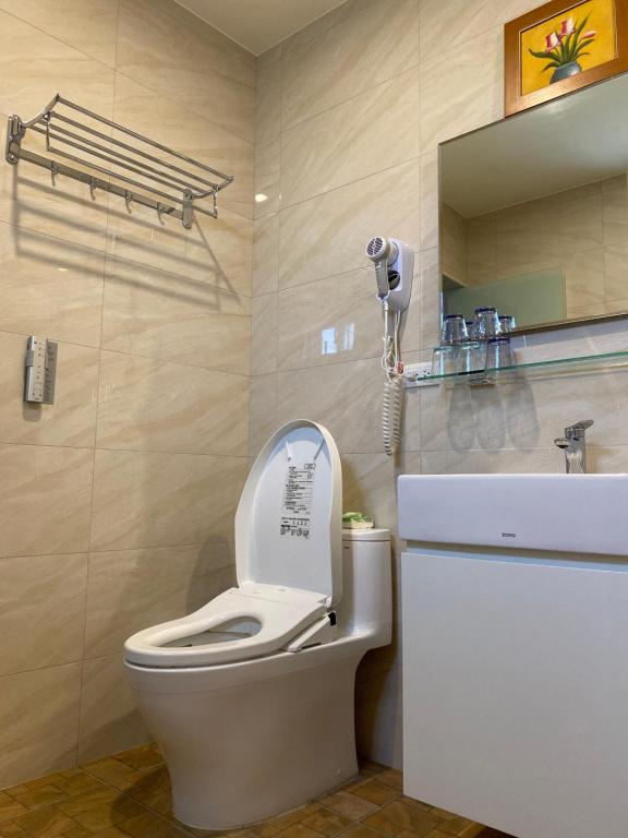 a bathroom with a toilet and a sink and a phone at Lily Garden Homestay in Yilan City