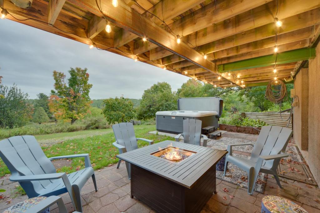 a patio with a table and chairs and a grill at Hermantown Home with Decks, Grill and Hot Tub! in Hermantown