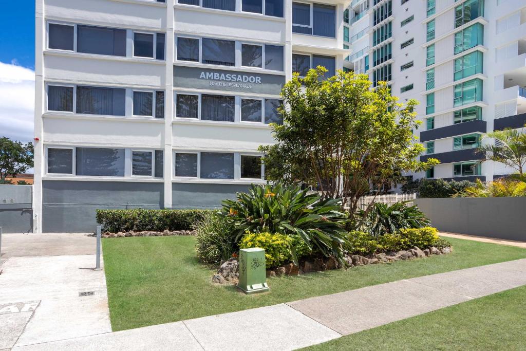 an apartment building with a garden in front of it at Ambassador Beachfront Apartments - Hosted by Burleigh Letting in Gold Coast