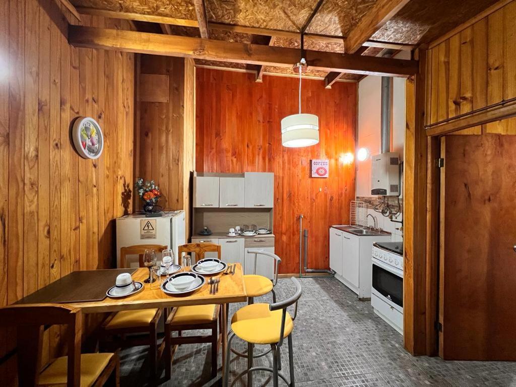 uma cozinha com mesa e cadeiras num quarto em Departamento D em Coihaique