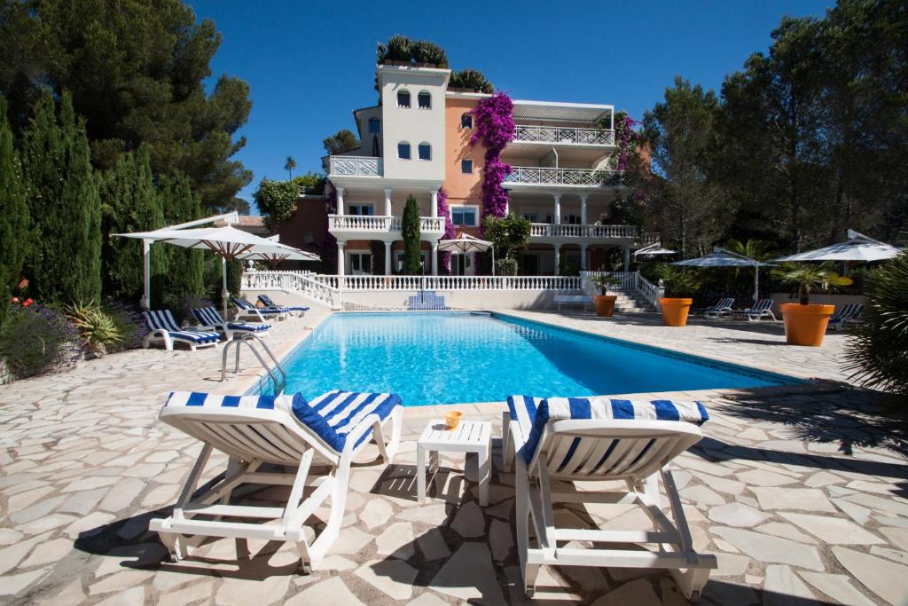 einen Pool mit Stühlen und ein Gebäude in der Unterkunft Chambre d'hôtes La Potinière in Saint-Raphaël