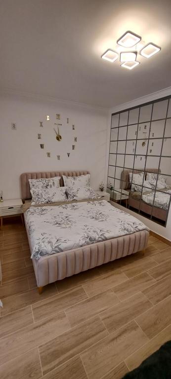 1 dormitorio con 1 cama y reloj en la pared en CozyStudio10, en Roşu