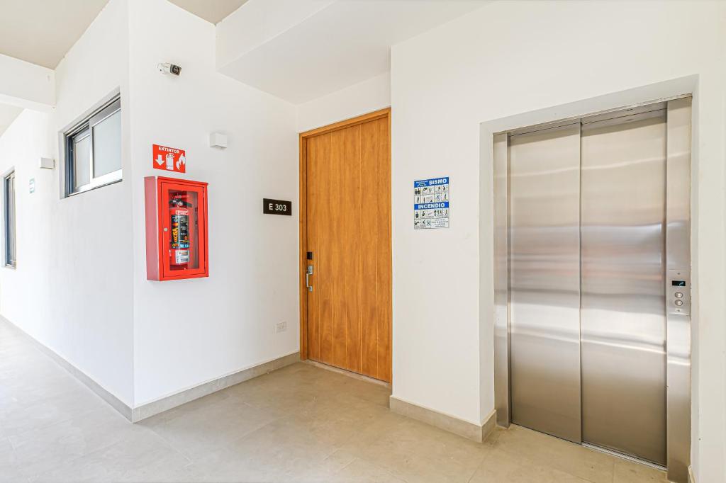 a hallway with a elevator and a wooden door at Lumina at Cardinal San José del Cabo in San José del Cabo