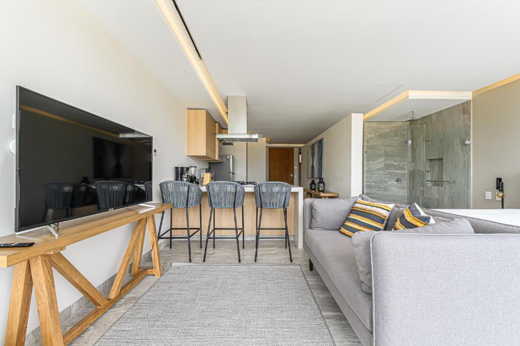 a living room with a couch and a table with chairs at Lumina at Cardinal San José del Cabo in San José del Cabo
