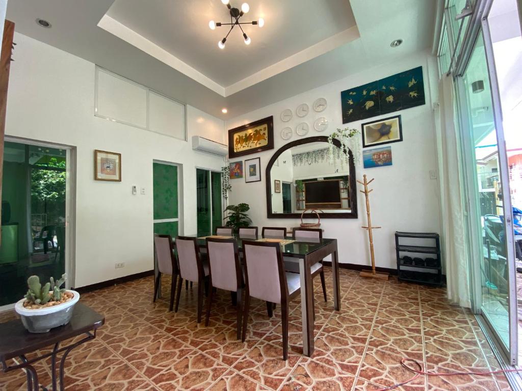 a dining room with a table and chairs and a mirror at 1-BR spacious lofted apartment near BGC Taguig City (THR105) in Manila