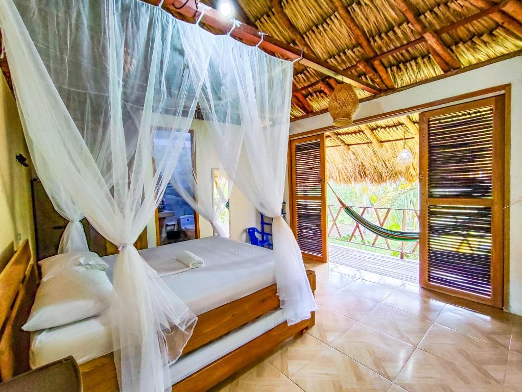 a bedroom with a bed with a mosquito net at Maria Moñitos Hostel in Moñitos