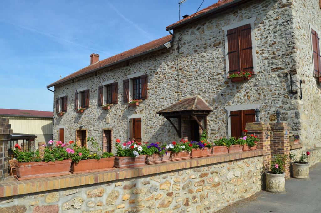 a stone building with flowerpots on the side of it at Chambres D'hotes & Champagne Douard in La Chapelle-Monthodon