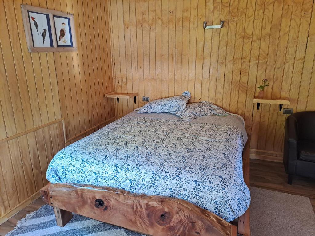 a bedroom with a bed made out of a log at Cabaña El Canelo in Puerto Varas