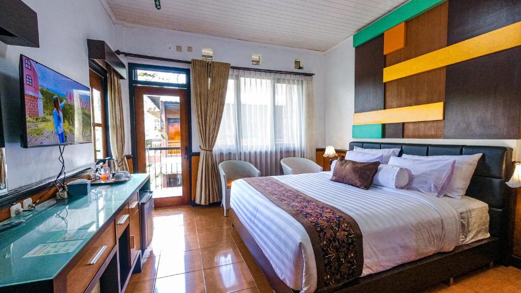 a hotel room with a bed and a television at Kebun Teh Wonosari Rollaas Hotel & Resort in Malang