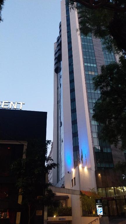 a tall building with blue lights in front of it at Apartamento em São paulo jardins oscar Freire com vaga in Sao Paulo