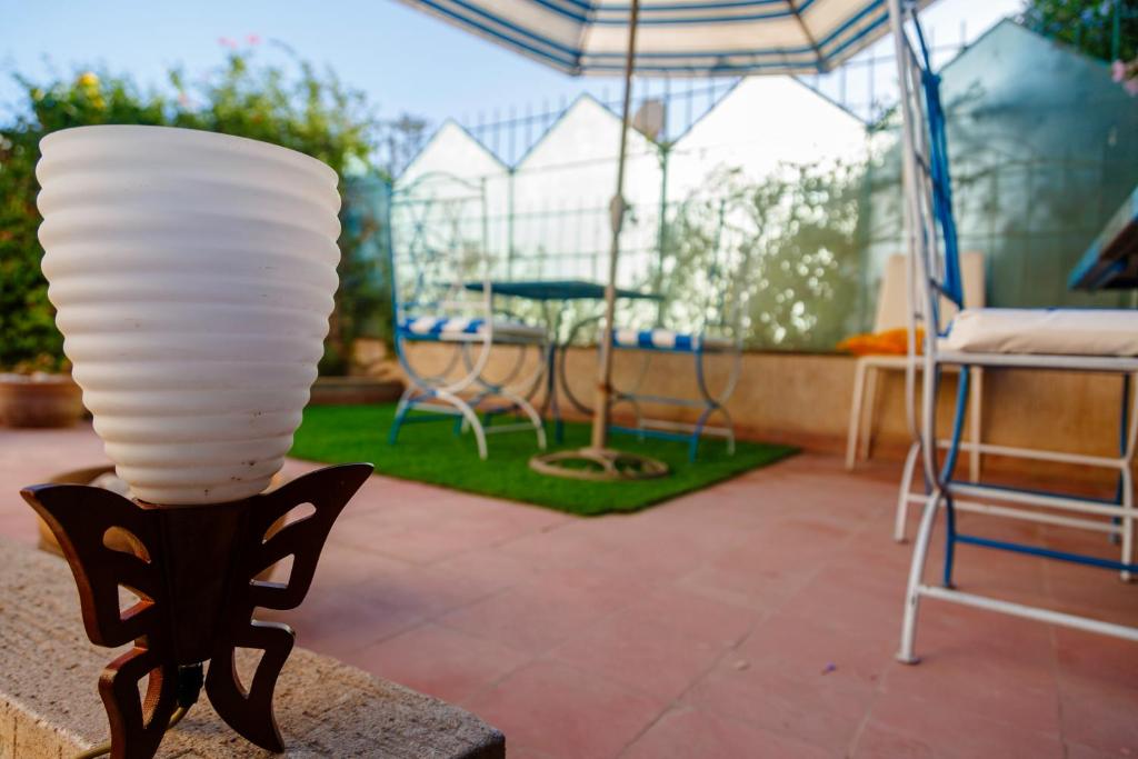 a lamp in a patio with chairs and an umbrella at CoWork & Stay Suites in Agadir