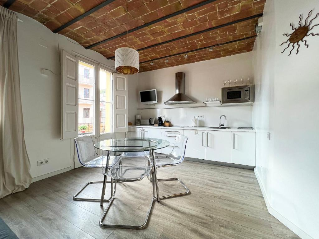 eine Küche mit einem Tisch und Stühlen im Zimmer in der Unterkunft Stay U-nique Apartments Fontrodona in Barcelona