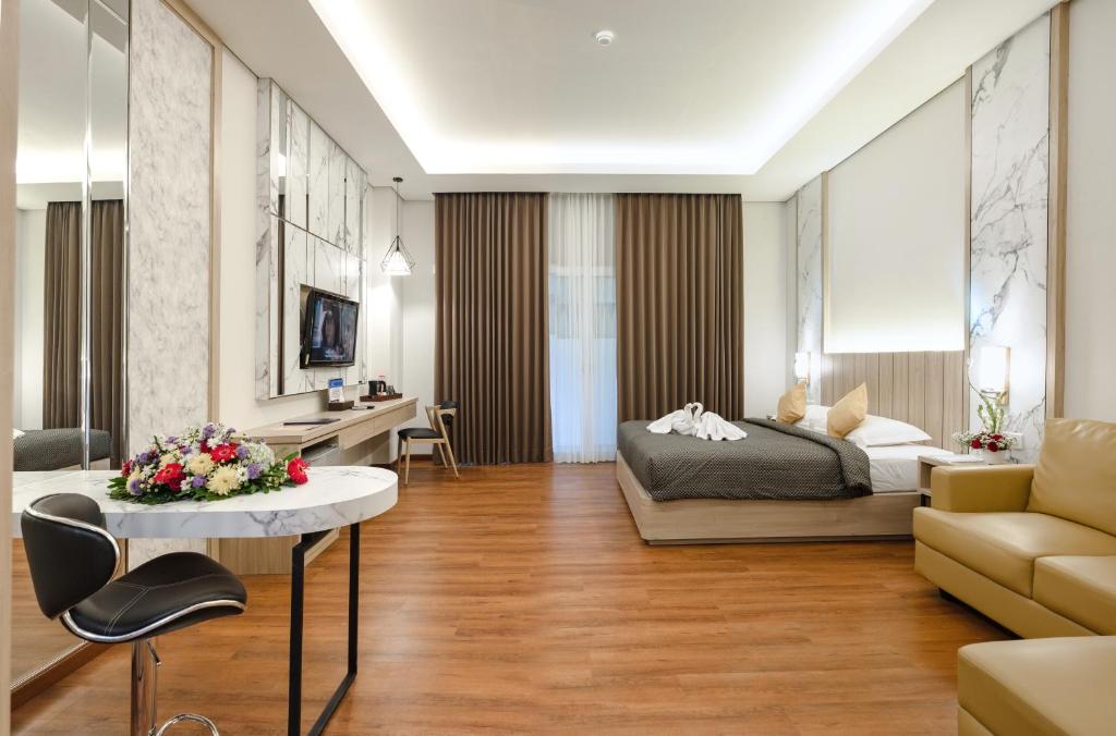 a bedroom with a bed and a living room at Aliante Malang in Malang