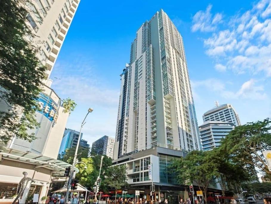 a tall glass building in a city with people at Comfy 2B1B CBD Riverview apt w Parking+Pool+Gym in Brisbane