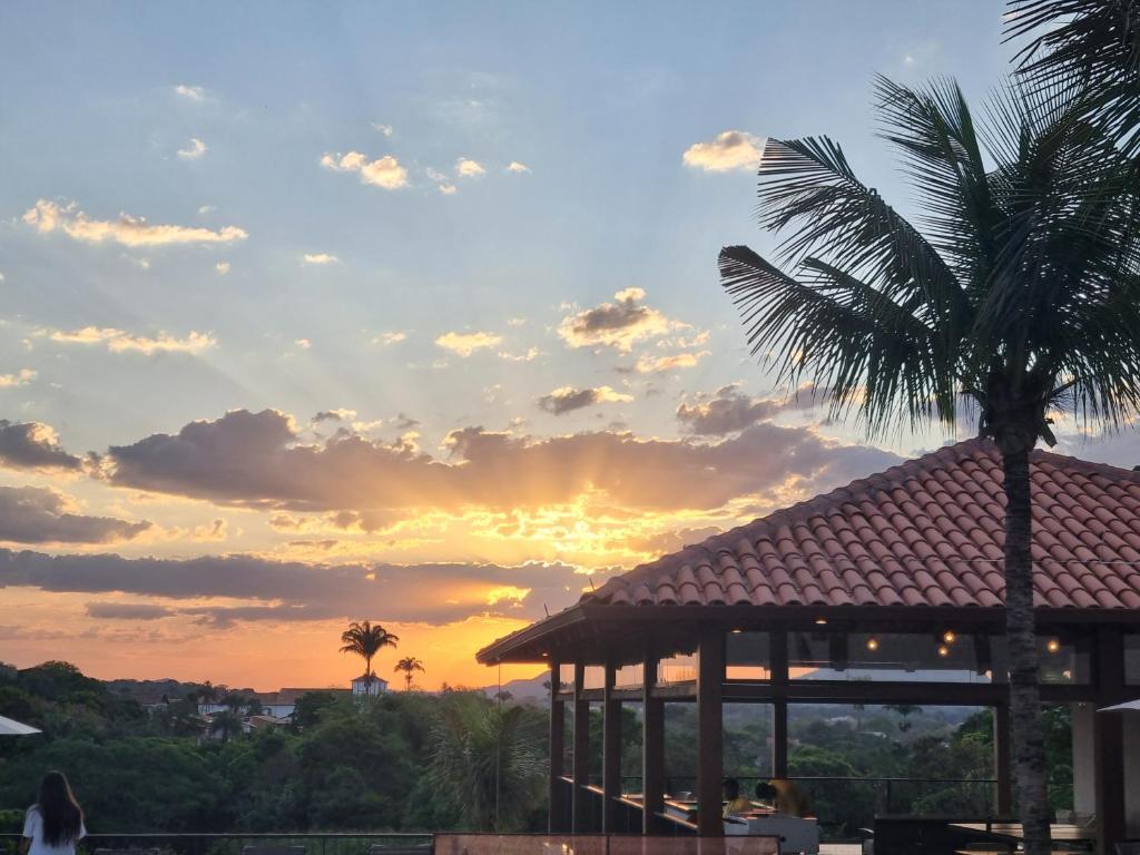 eine Palme und ein Pavillon bei Sonnenuntergang in der Unterkunft Quinta de Santa Bárbara Eco Resort Luxo Reveillon in Pirenópolis