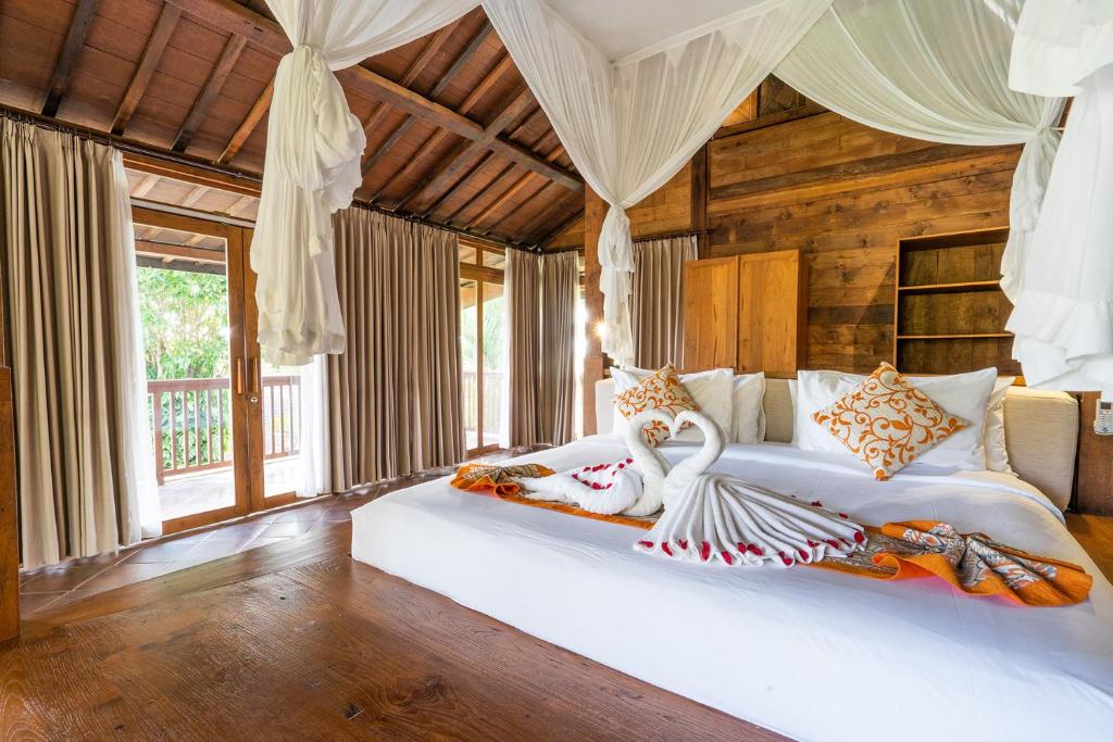 1 dormitorio con 2 camas en una habitación con paredes de madera en Ayawana Private Villas Managed by ARM Hospitality, en Tegalalang