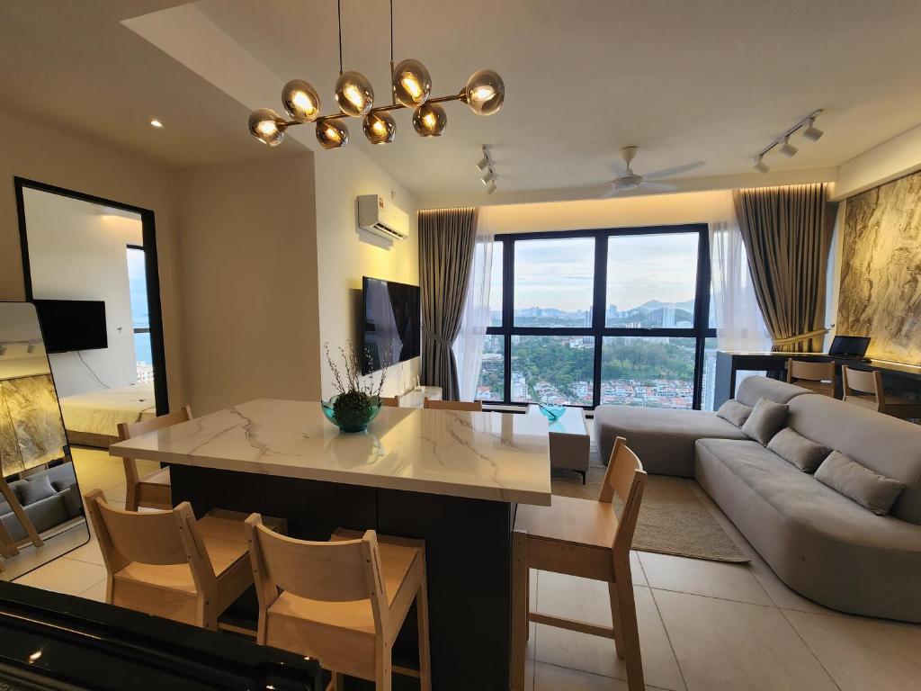 een woonkamer met een tafel en een bank bij Urban Suites - Penang in Jelutong