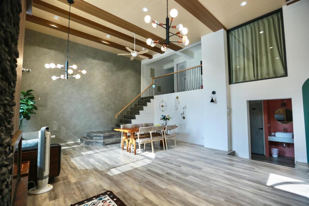 a living room with a table and a staircase at 青逸居 桃園中壢民宿 親子包棟 Qing Yi Ju in Zhongli