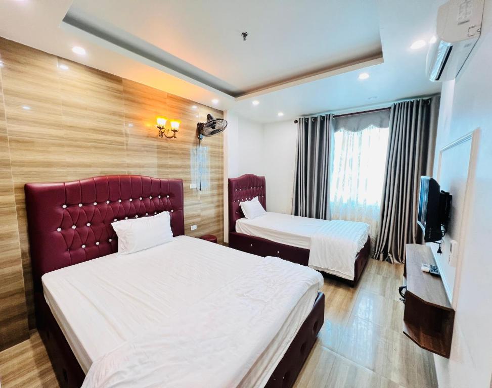 a hotel room with two beds and a television at Thủ Đô Vàng Hotel - QL6 Hà Đông - by Bay Luxury in Hà Ðông