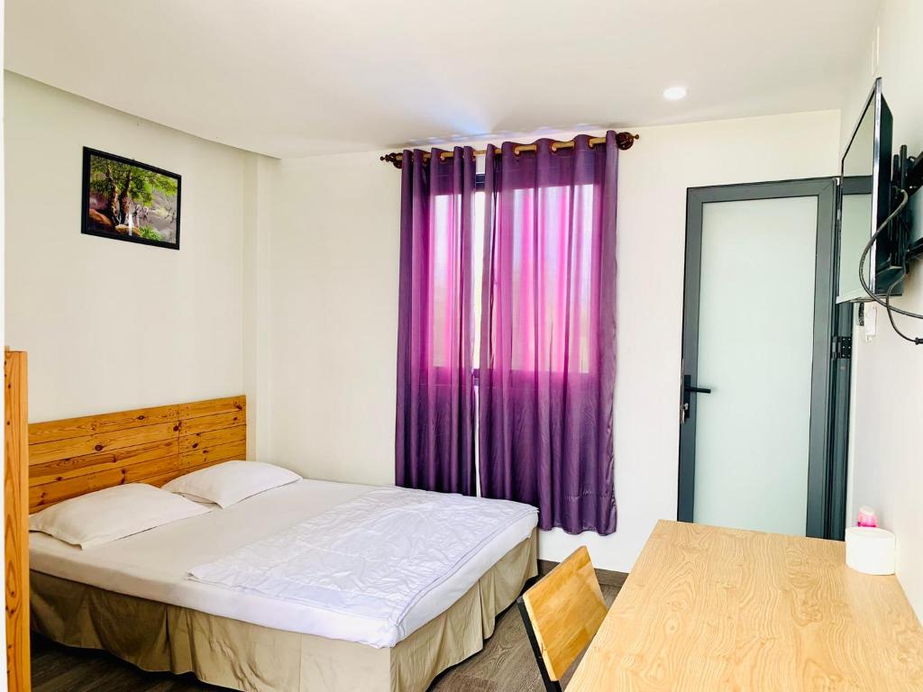 a bedroom with a bed and a purple curtain at Homestay KV in Can Tho