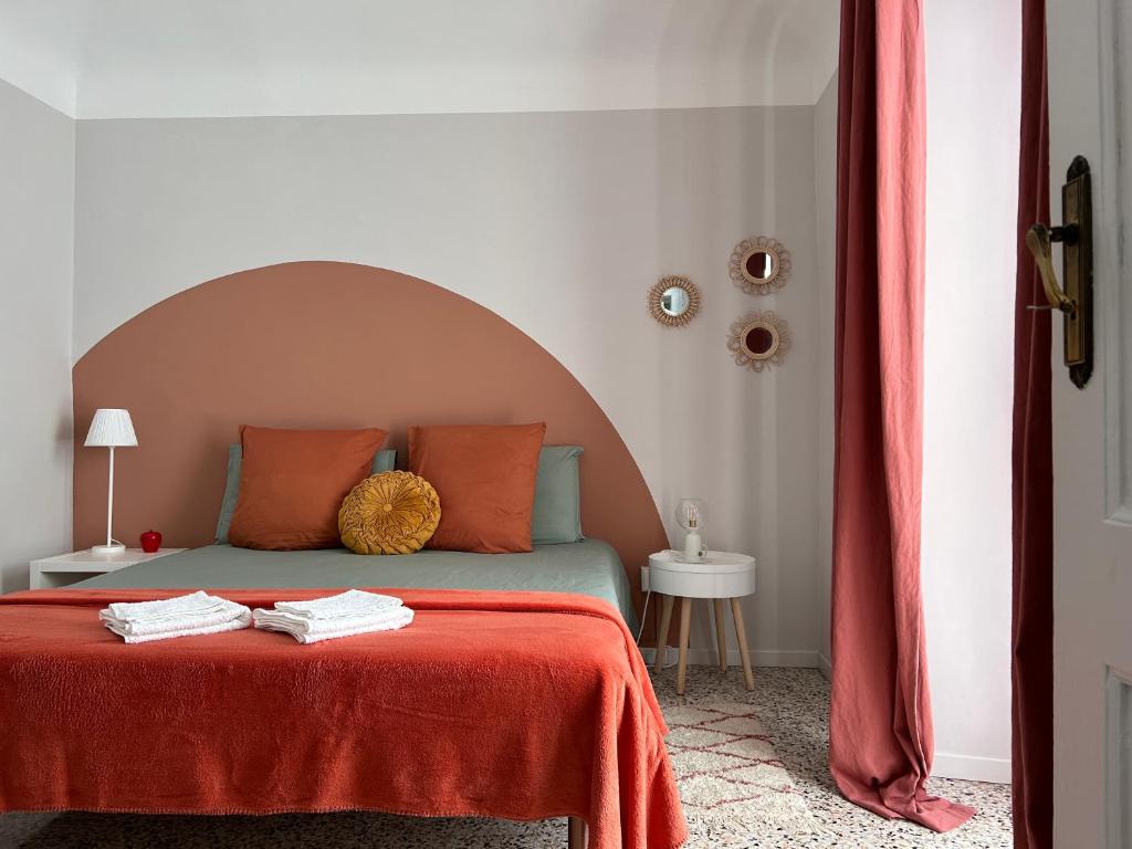 a bedroom with a bed with a red blanket at Casa Mafalda trilocale in centro in Biella