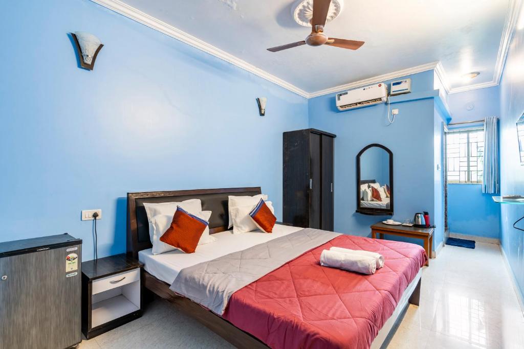 a bedroom with a bed with blue walls and a ceiling at Last Minute Trip Hostel Morjim-By The Sea in Morjim