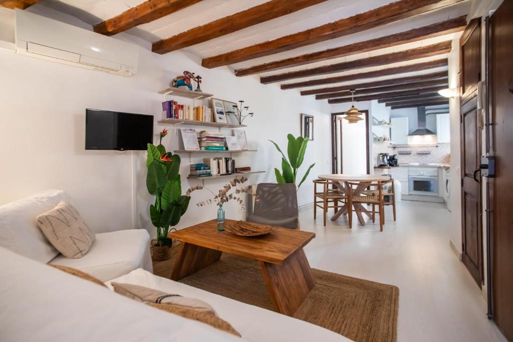 42enf1060 - Authentic &Centric Barcelonian 2BR flat في برشلونة: غرفة معيشة مع أريكة بيضاء وطاولة
