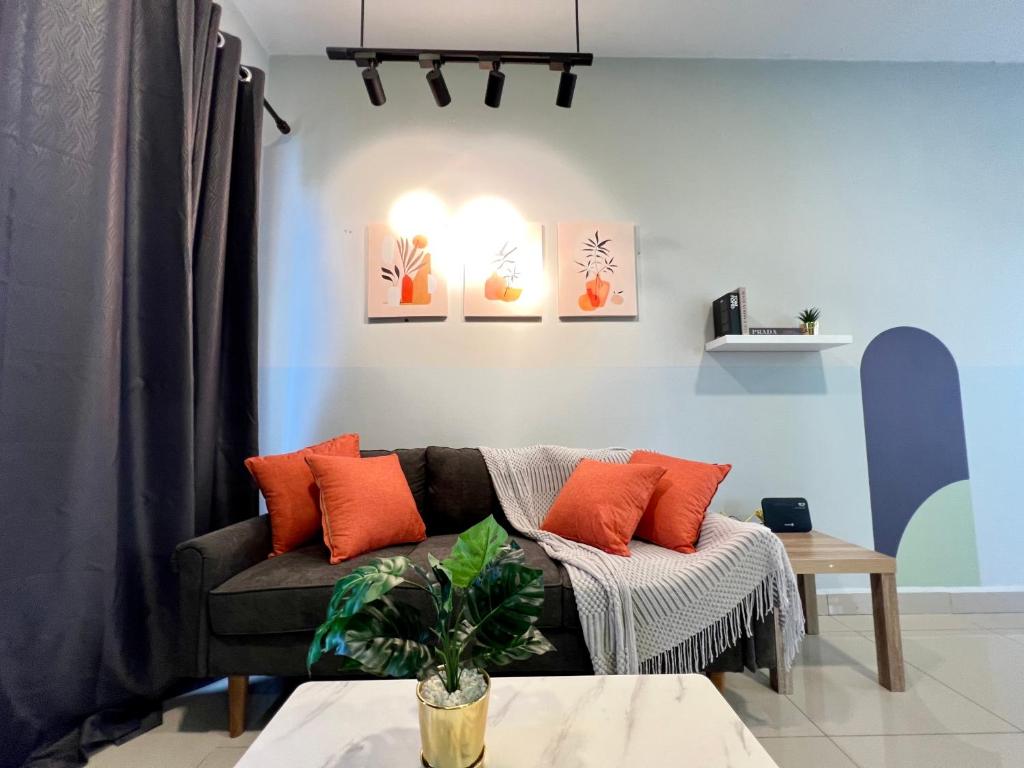 een woonkamer met een bank met oranje kussens bij RiverView 8PAX 2BR in KBtown PS4, Netflix A-1-12 in Kota Bharu