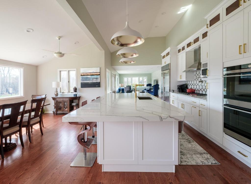 a kitchen with white cabinets and a large white island at 2-Acre Highland Park Retreat with Heated Pool ~ 5* in Highland Park