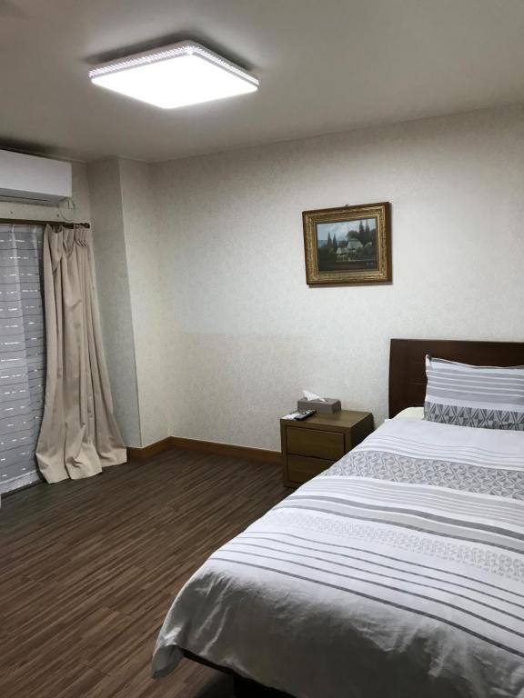a bedroom with a large bed and a window at ゴールデンビーチホテル in Katakai