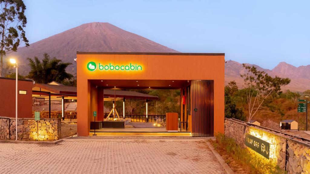 an orange building with a mountain in the background at Bobocabin Gunung Rinjani, Lombok in Sembalun Lawang