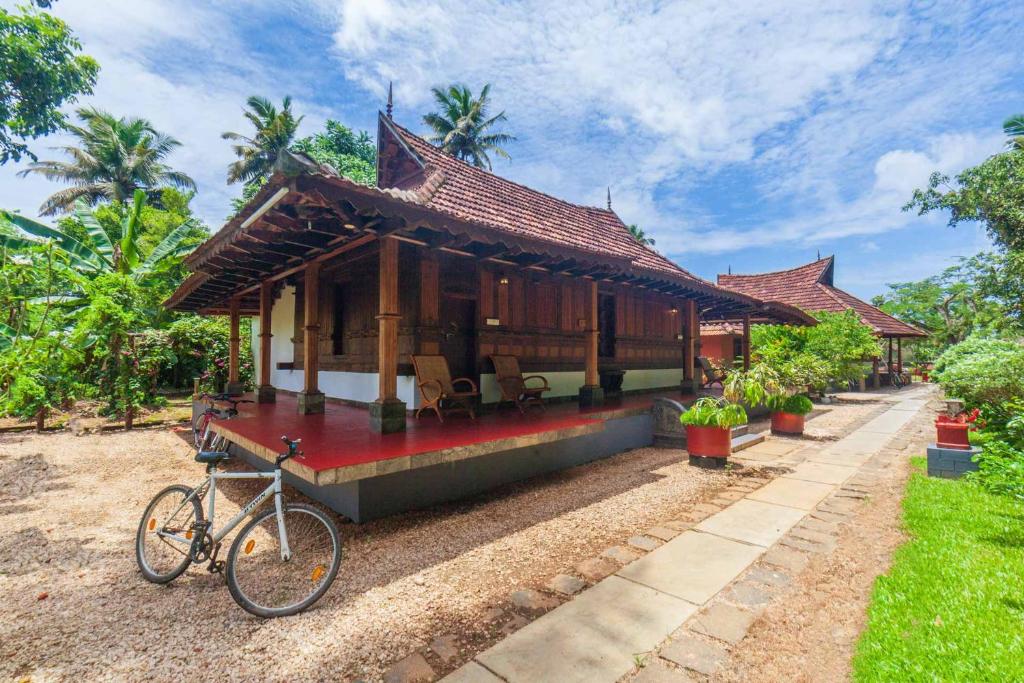 a bike parked in front of a house at StayVista at La Riva Heritage Villa with Bicycle in Alleppey