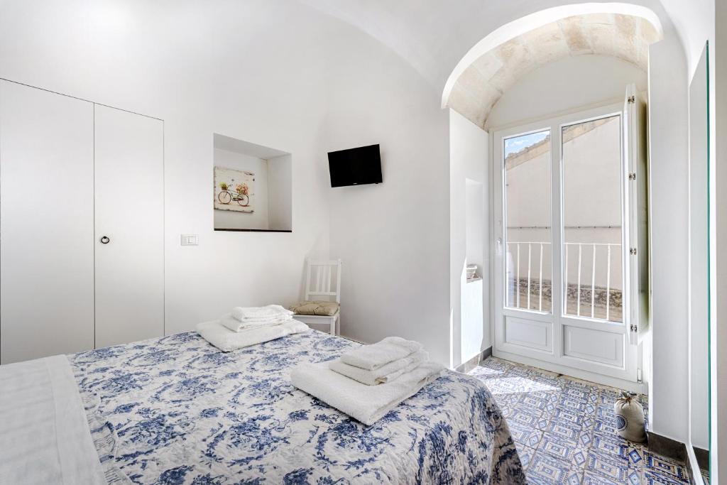 ラグーザにあるIl Quartino Di Palazzo Maggioreの白いベッドルーム(ベッド1台、窓付)