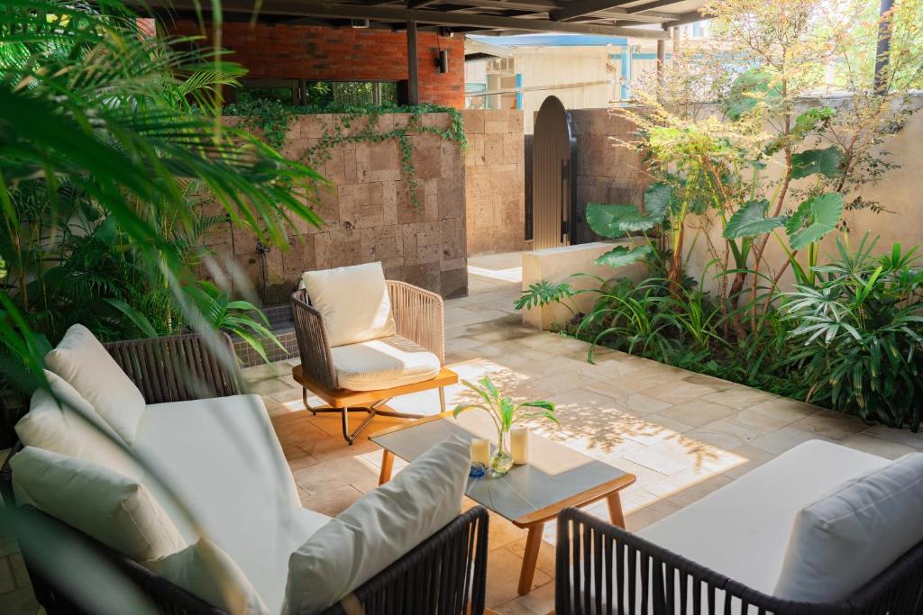 un patio con 2 sofás, una mesa y sillas en Flowering Villa, en Xiaoliuqiu