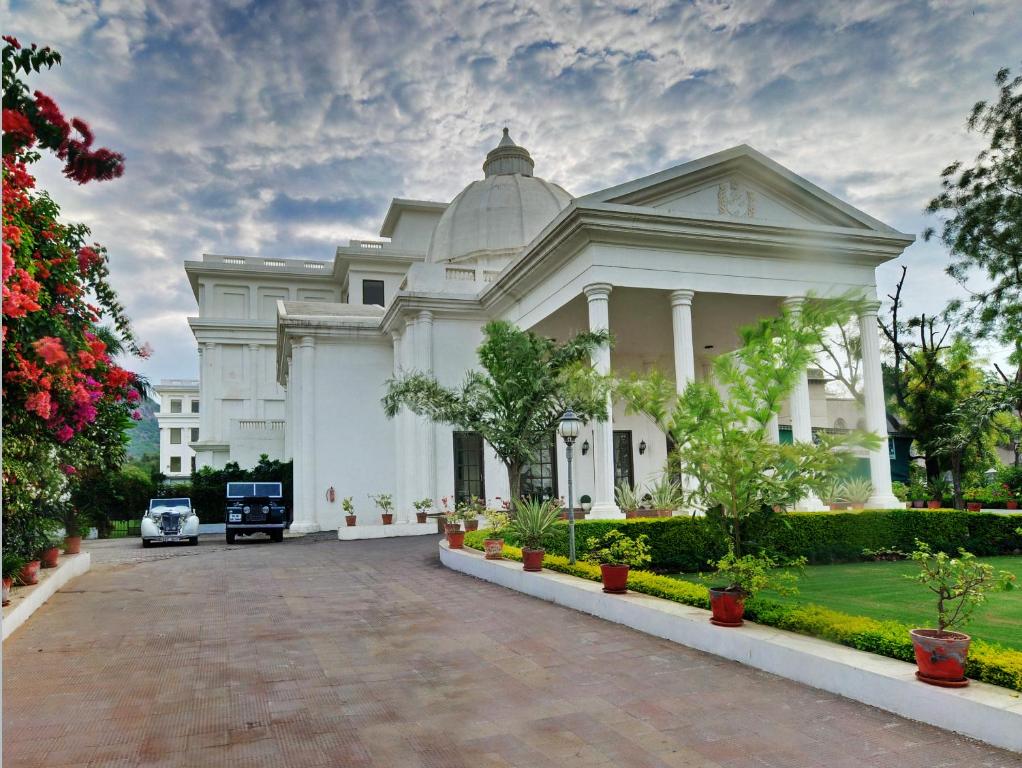 un edificio blanco con un coche aparcado delante de él en The Hadoti Palace, Bundi, en Bundi