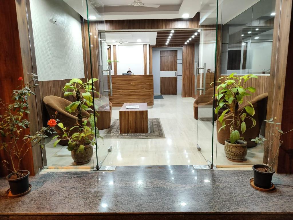 un hall de bureau avec des plantes en pot et un bureau dans l'établissement Hotel Bulande Comforts-1 Bedroom Flat, à Bangalore