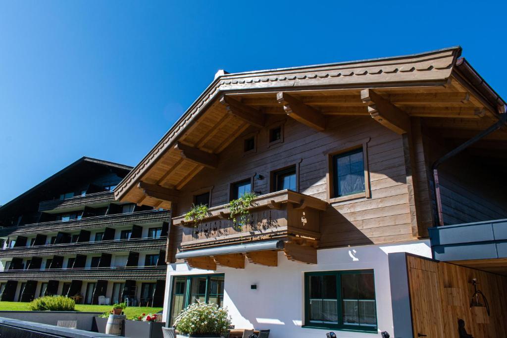 a house with a balcony in front of a building at Weinzeit Chalet & Appartements in Königsleiten
