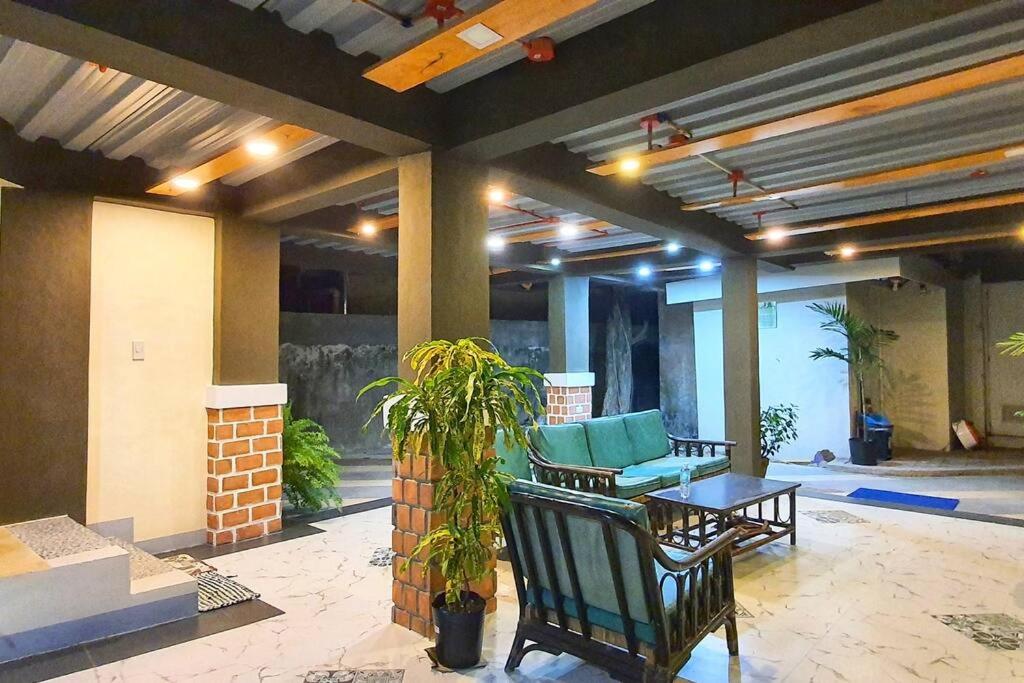 a patio with two chairs and a table and a couch at 2 Houses w/ parking for best guest in Iloilo City