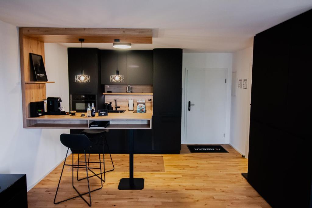 a kitchen with black cabinets and a bar with stools at KOCAK - Exklusives Apartment in Zentrumsnähe in Reutlingen