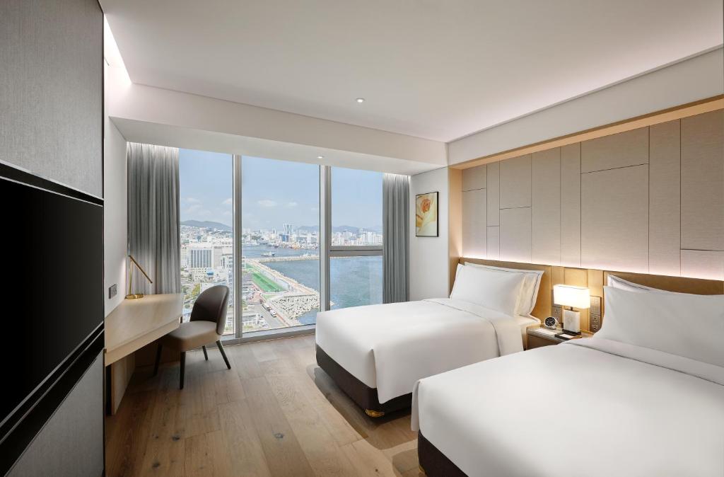 Postel nebo postele na pokoji v ubytování Wyndham Grand Busan