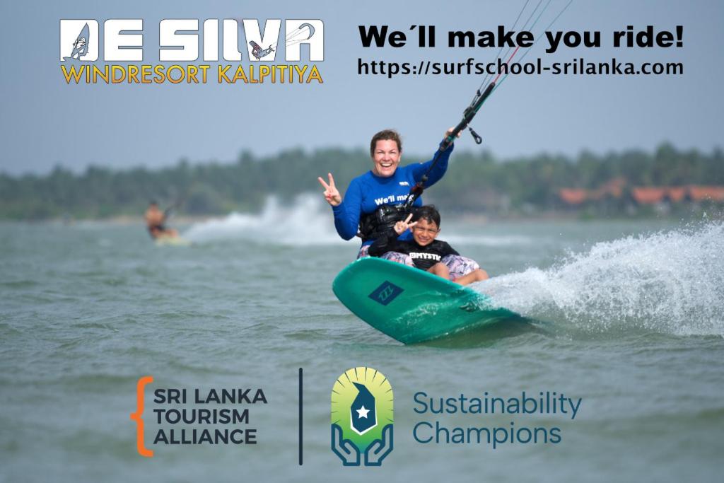un hombre y un niño en una tabla de surf en el agua en De Silva Palm Resort, en Kalpitiya