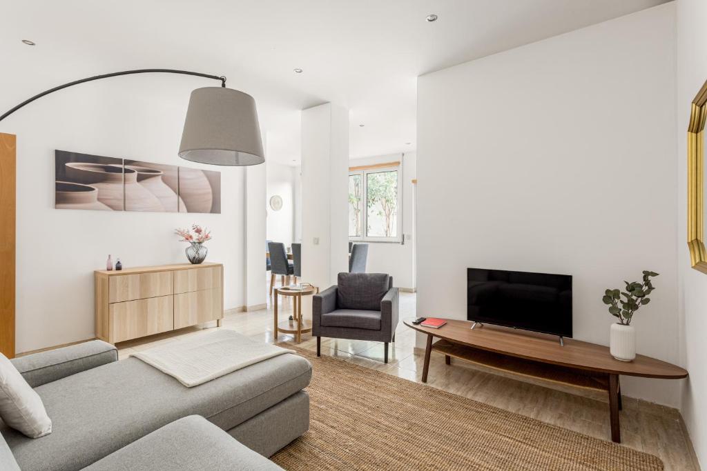 uma sala de estar com um sofá e uma televisão em Altido Central & spacious apt in Porto no Porto