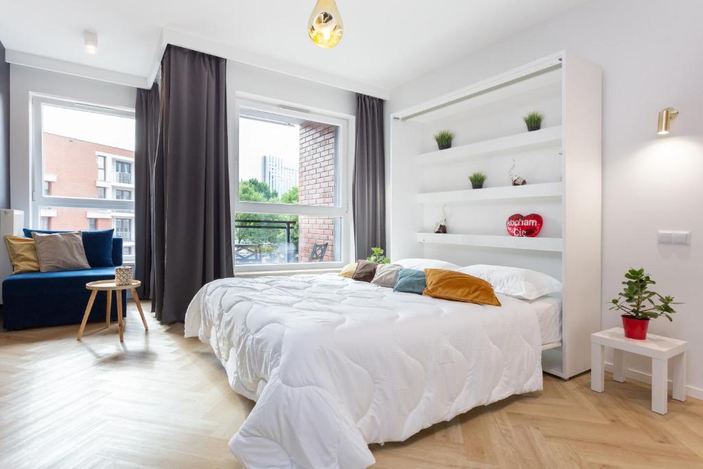 a white bedroom with a large bed and a window at AVRA Residence II Stare Miasto in Gdańsk
