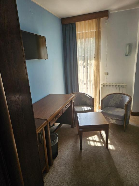 Habitación con escritorio, sofá y mesa. en APT Properties en Čukarica
