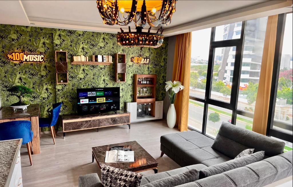 a living room with a couch and a tv at ATLAS SUİT in Çiftlikköy