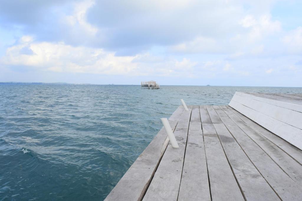 een dok in de oceaan met een boot in het water bij Kelong Bintan in Telukbakau